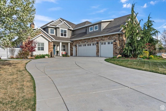 13379 S Elda Rae Cir W, Riverton, UT 84065 - view of front facade with a chimney, fence, concrete driveway, an attached garage, and stone siding
