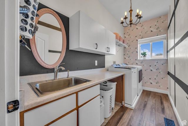1563 Bryan Rd, Erda, UT 84074 - clothes washing area featuring washer and clothes dryer, visible vents, a sink, light wood-style floors, and cabinet space