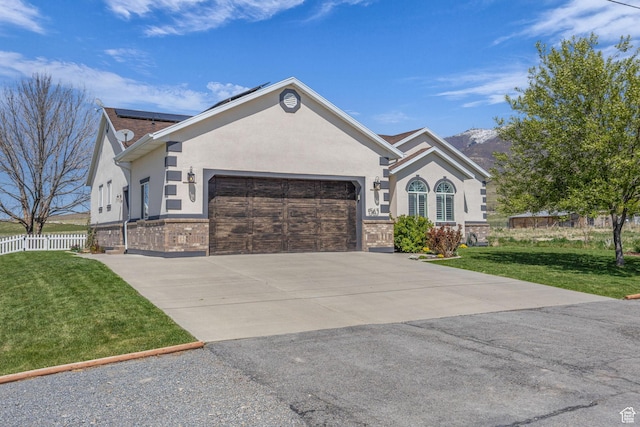 1563 Bryan Rd, Erda, UT 84074 - ranch-style home featuring concrete driveway, a front lawn, a garage, stucco siding, and solar panels
