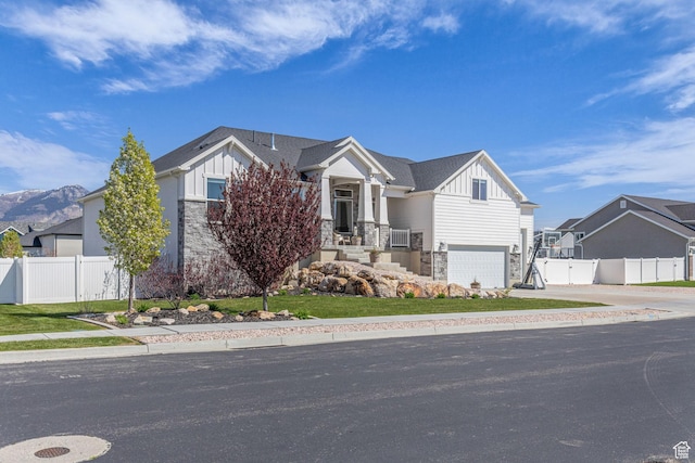 2364 N 2400 W, Farr West, UT 84404 - view of front of house featuring board and batten siding, an attached garage, stone siding, and fence