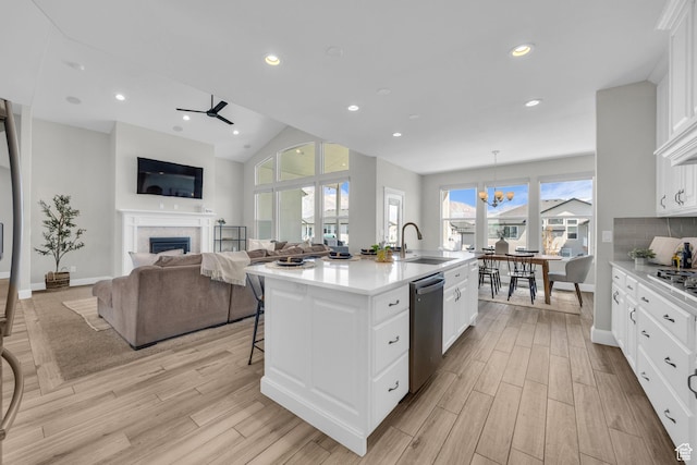 2364 N 2400 W, Farr West, UT 84404 - kitchen featuring a sink, an island with sink, stainless steel appliances, light wood finished floors, and a fireplace