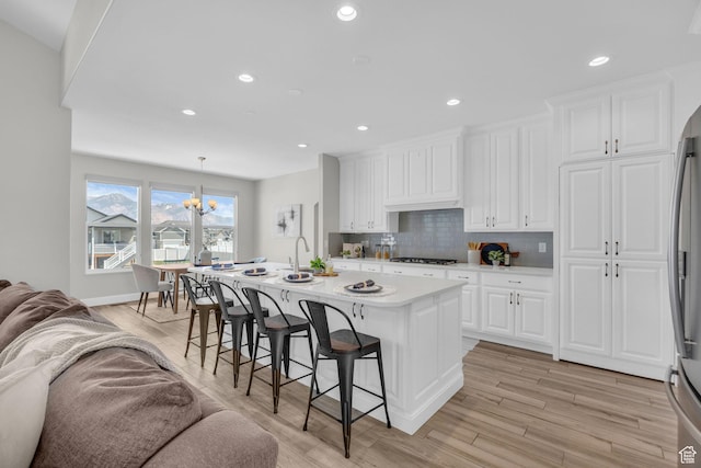 2364 N 2400 W, Farr West, UT 84404 - kitchen with a kitchen bar, open floor plan, white cabinetry, and light countertops