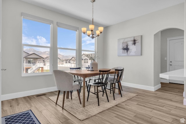 2364 N 2400 W, Farr West, UT 84404 - dining area featuring arched walkways, light wood-style flooring, a wealth of natural light, and an inviting chandelier