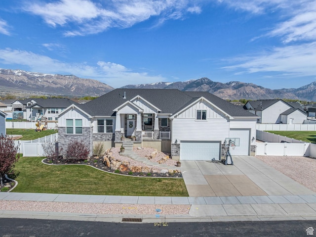 2364 N 2400 W, Farr West, UT 84404 - view of front of house featuring a mountain view, stone siding, a garage, board and batten siding, and a front yard