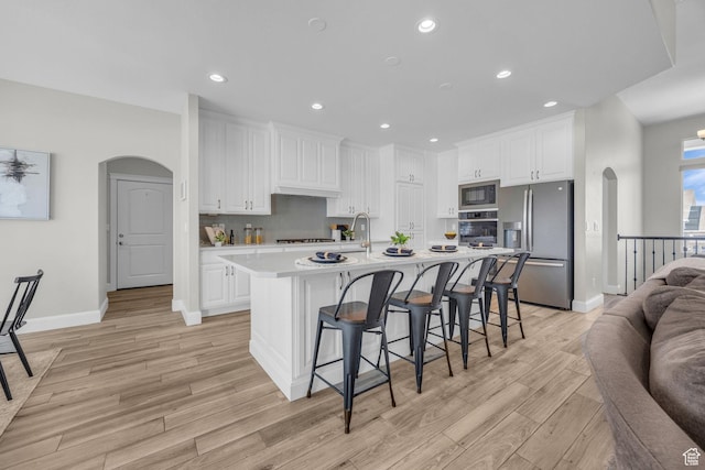 2364 N 2400 W, Farr West, UT 84404 - kitchen with arched walkways, light wood-style floors, and appliances with stainless steel finishes