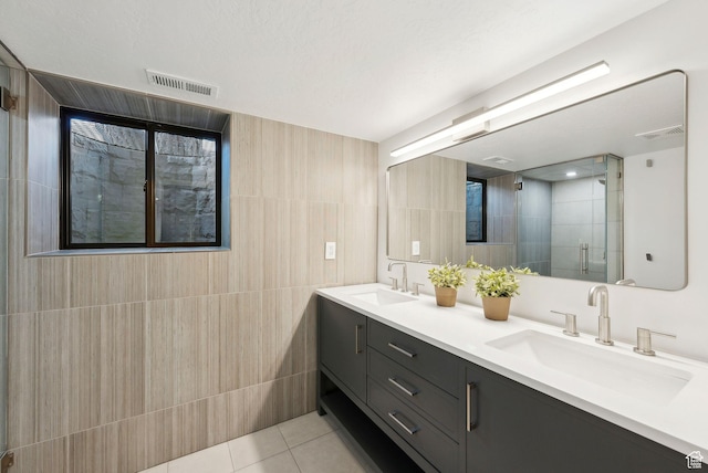 full bathroom with a sink, visible vents, and tile walls