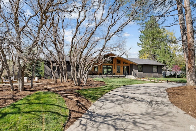 view of front of home with a front lawn and curved driveway