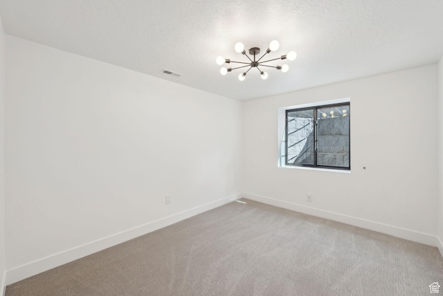 empty room featuring a chandelier, visible vents, baseboards, and light carpet