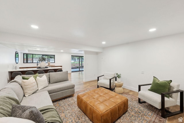 living area with baseboards, light wood-style flooring, and recessed lighting
