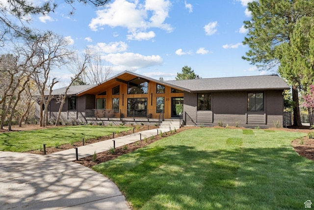 view of front of house featuring a shingled roof and a front lawn