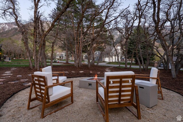 view of patio with a mountain view and an outdoor fire pit