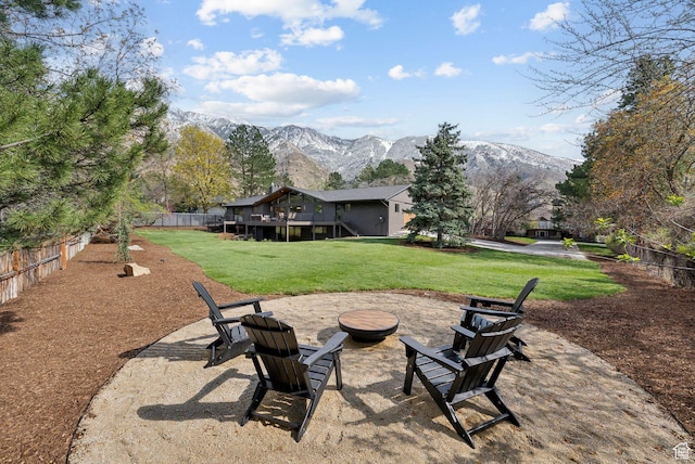 view of yard with a fire pit, fence, and a deck with mountain view