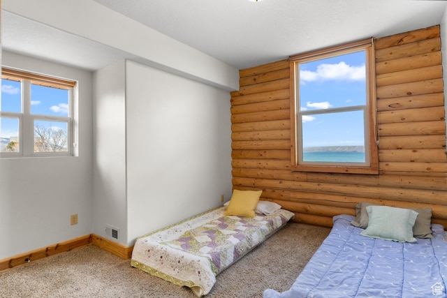 2292 S Aspen Loop, Garden City, UT 84028 - bedroom featuring rustic walls, carpet floors, visible vents, and baseboards