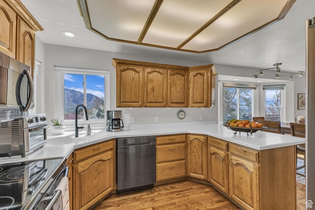305 E 3700 N, North Ogden, UT 84414 - kitchen with brown cabinets, light countertops, a sink, a peninsula, and appliances with stainless steel finishes