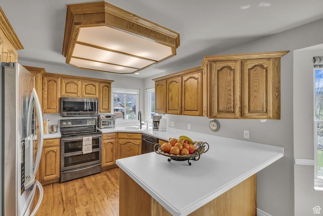 305 E 3700 N, North Ogden, UT 84414 - kitchen featuring light countertops, a sink, a peninsula, light wood-style flooring, and appliances with stainless steel finishes