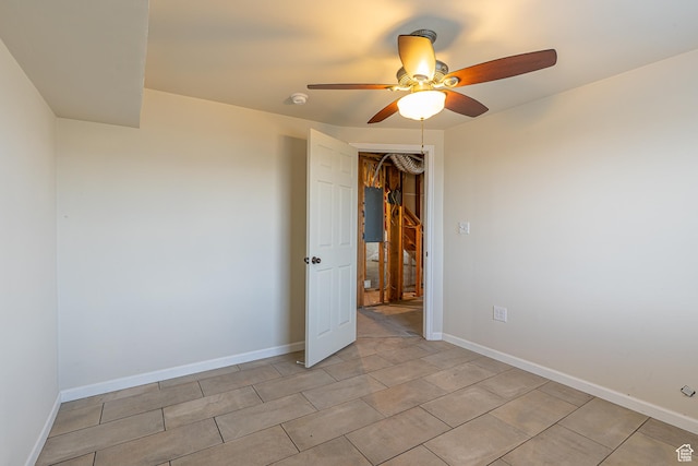 spare room featuring light tile patterned flooring, baseboards, and ceiling fan