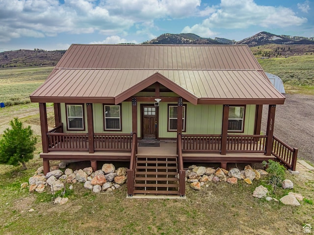 view of front of home with metal roof, covered porch, and a mountain view