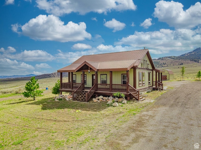 chalet / cabin with board and batten siding, a porch, metal roof, and a mountain view