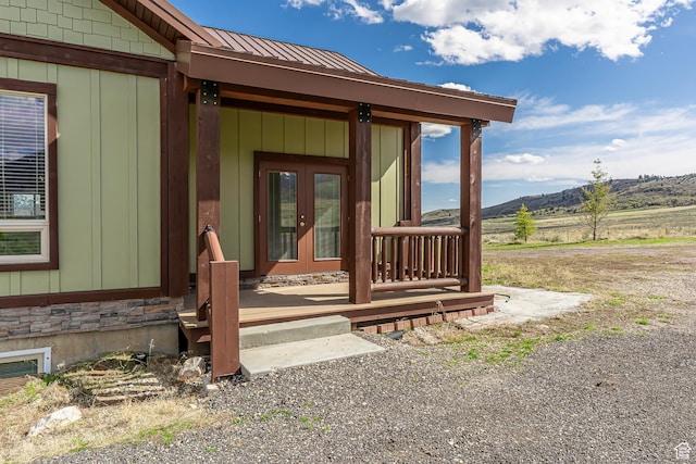 property entrance with french doors, a mountain view, and metal roof