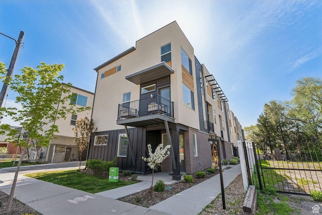 306 W Azure Sky Ln, Salt Lake City, UT 84103 - view of front facade featuring stucco siding, a balcony, and fence