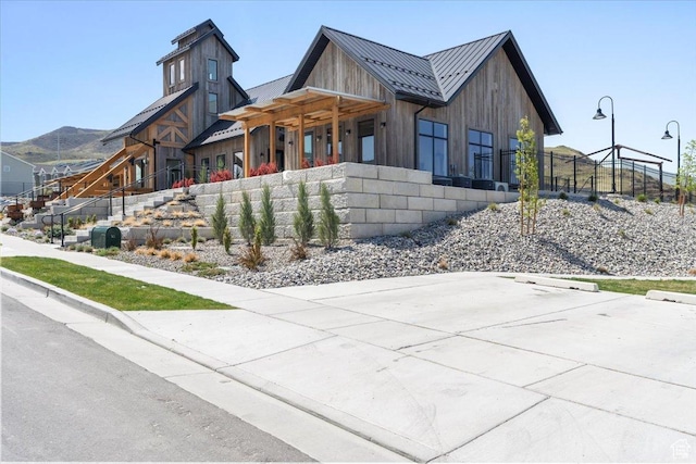 view of side of property with fence, a standing seam roof, board and batten siding, and metal roof