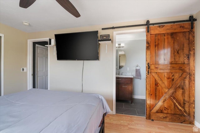 498 E 3000 N, North Ogden, UT 84414 - bedroom featuring light wood-style flooring, a barn door, ensuite bathroom, baseboards, and ceiling fan