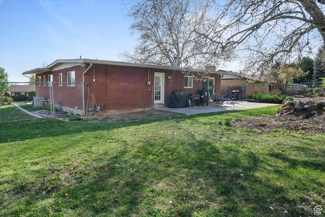 498 E 3000 N, North Ogden, UT 84414 - rear view of house with brick siding, a patio area, a lawn, and fence