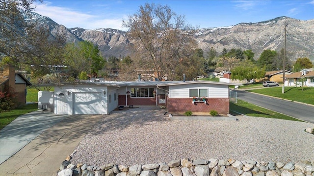 498 E 3000 N, North Ogden, UT 84414 - ranch-style house with driveway, covered porch, an attached garage, a mountain view, and brick siding