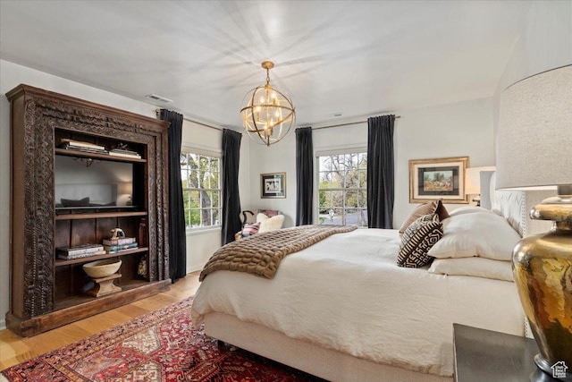 1904 E Yalecrest Ave S, Salt Lake City, UT 84108 - bedroom with visible vents, wood finished floors, an inviting chandelier, and multiple windows