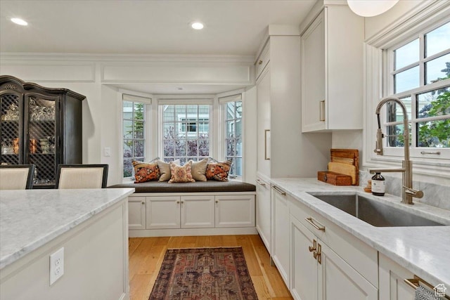 1904 E Yalecrest Ave S, Salt Lake City, UT 84108 - kitchen with light stone counters, a sink, light wood finished floors, white cabinetry, and recessed lighting