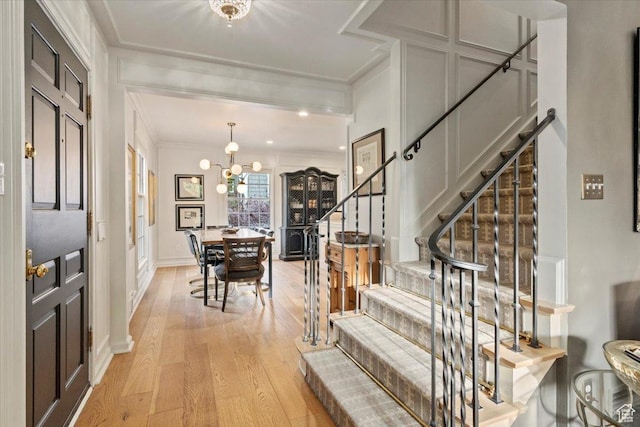 1904 E Yalecrest Ave S, Salt Lake City, UT 84108 - entryway featuring a notable chandelier, light wood-style floors, stairs, crown molding, and a decorative wall