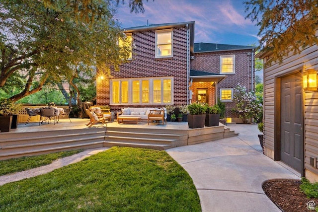 1904 E Yalecrest Ave S, Salt Lake City, UT 84108 - back of property at dusk with a lawn, outdoor lounge area, brick siding, and a deck