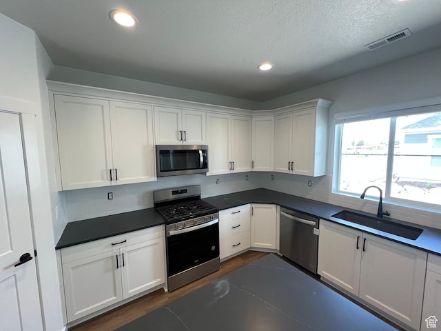 4 S 3830 W Unit 418, West Point, UT 84015 - kitchen featuring appliances with stainless steel finishes, a sink, white cabinetry, dark countertops, and recessed lighting