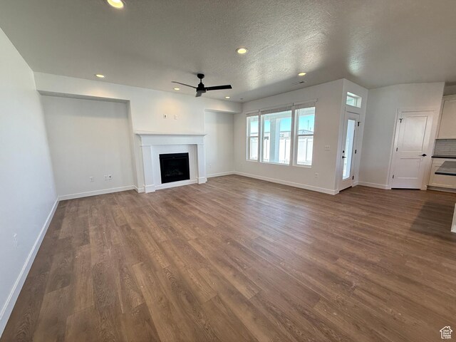 4 S 3830 W Unit 418, West Point, UT 84015 - unfurnished living room with a ceiling fan, baseboards, recessed lighting, dark wood-style floors, and a fireplace