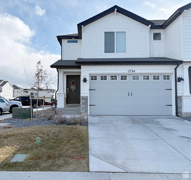 view of front of home featuring stone siding, driveway, and a garage
