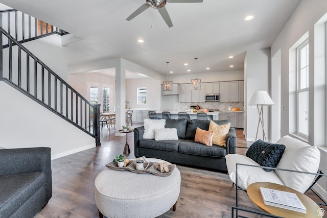 living room with stairway, ceiling fan, wood finished floors, and recessed lighting