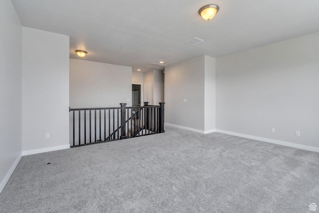 carpeted spare room with baseboards, visible vents, and recessed lighting