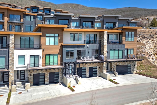 view of property featuring an attached garage, driveway, and a mountain view