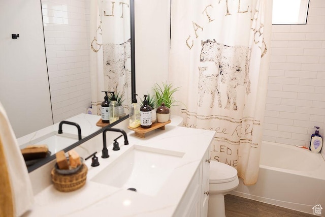 full bathroom with shower / bath combo with shower curtain, wood finished floors, vanity, and toilet