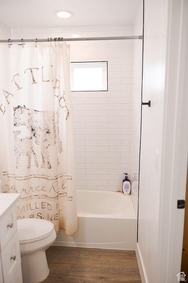 bathroom featuring shower / tub combo with curtain, wood finished floors, toilet, and vanity