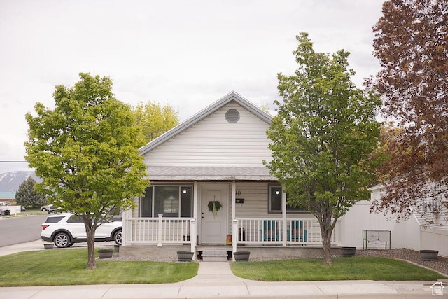 bungalow-style home featuring a front lawn and covered porch