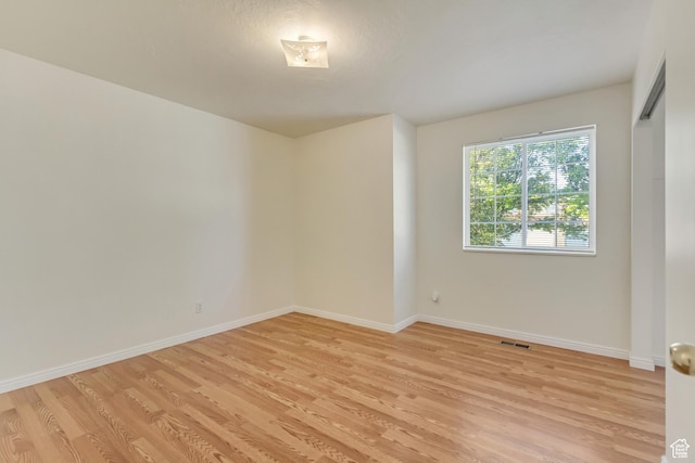 spare room with baseboards, visible vents, and light wood-type flooring