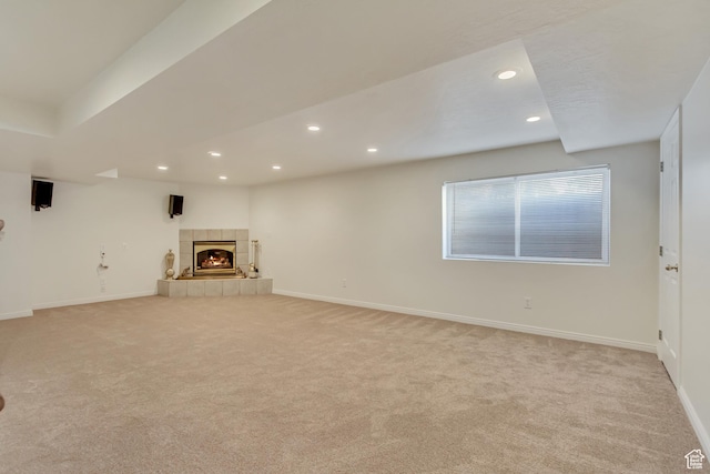 unfurnished living room with carpet, baseboards, a tile fireplace, and recessed lighting