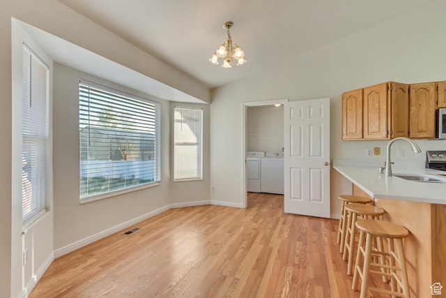 dining space featuring an inviting chandelier, light wood-style flooring, visible vents, and independent washer and dryer