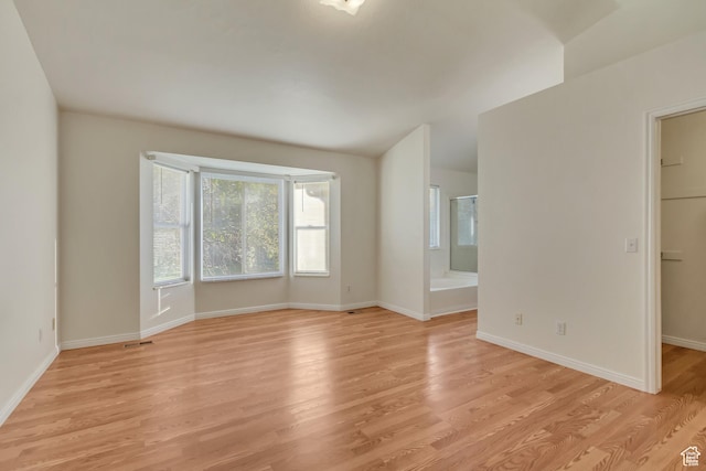 unfurnished room featuring baseboards, visible vents, and light wood finished floors
