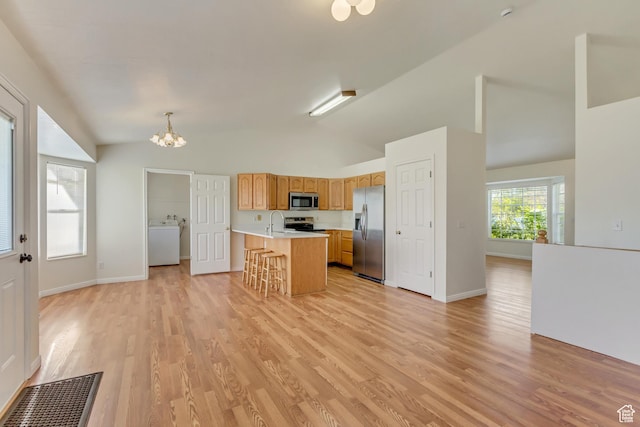 kitchen with stainless steel appliances, light countertops, visible vents, a sink, and washer / dryer