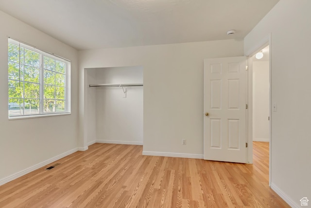 unfurnished bedroom with baseboards, visible vents, and light wood-style flooring