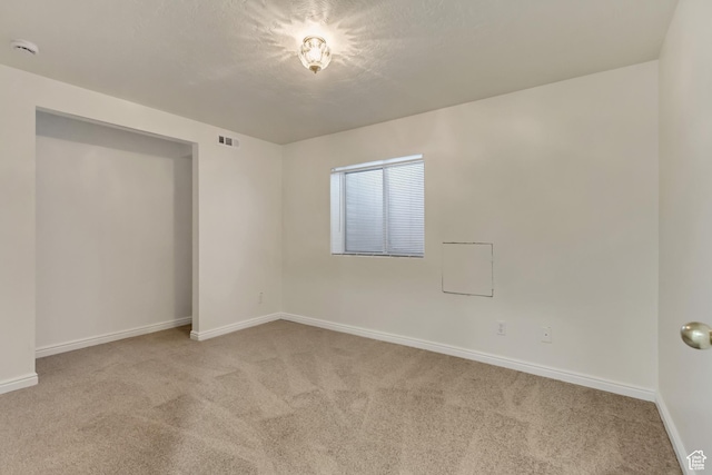 unfurnished room featuring light carpet, visible vents, and baseboards