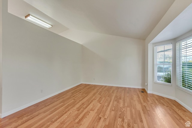 spare room featuring light wood finished floors and baseboards
