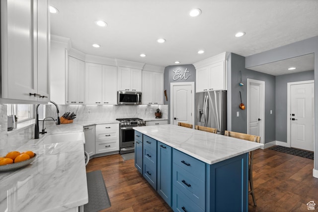 322 Flour Mill Dr, Kaysville, UT 84037 - kitchen with a sink, white cabinets, decorative backsplash, blue cabinetry, and appliances with stainless steel finishes